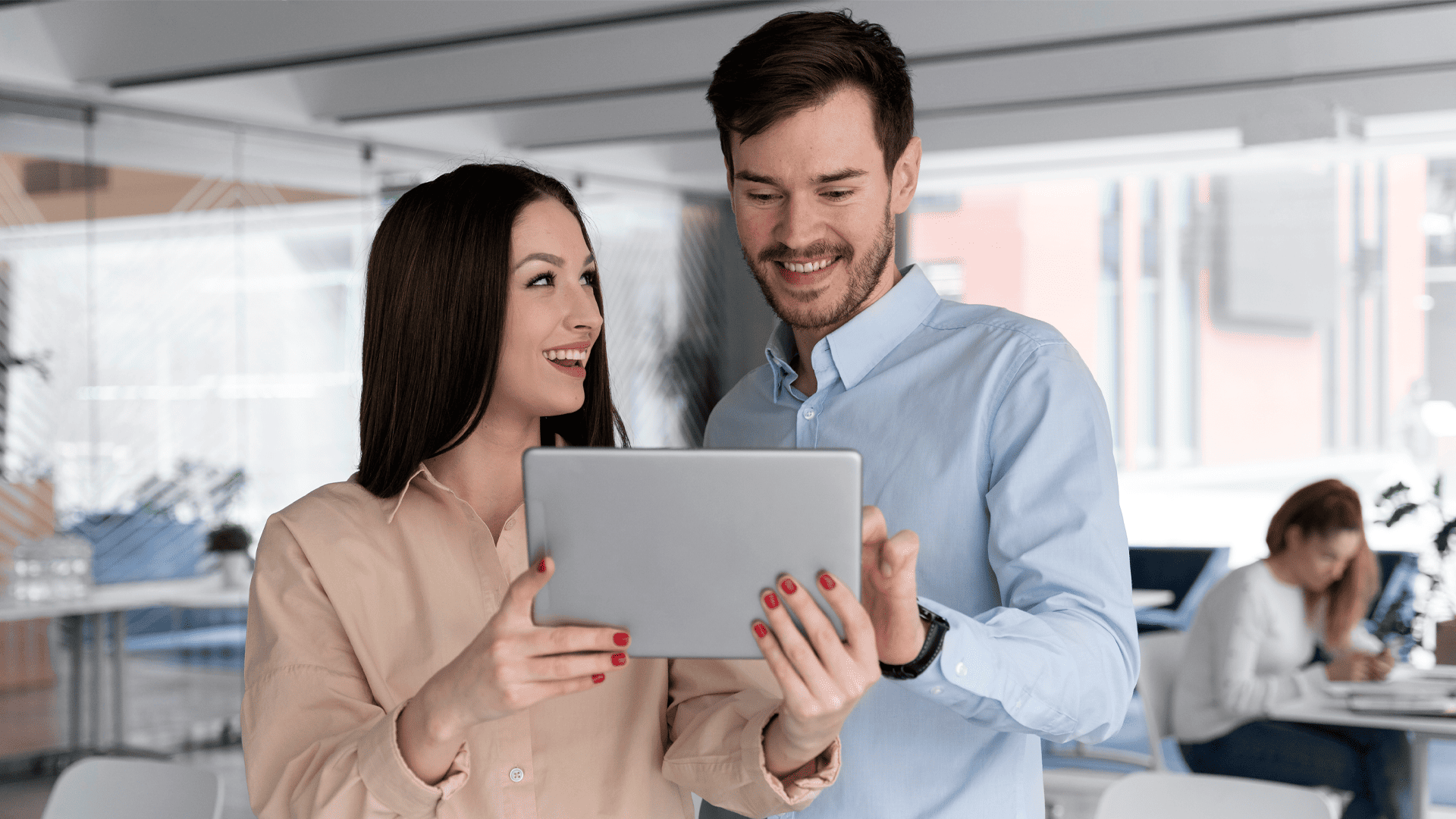 Um homem e uma mulher olhando para um tablet visando o seu desenvolvimento profissional